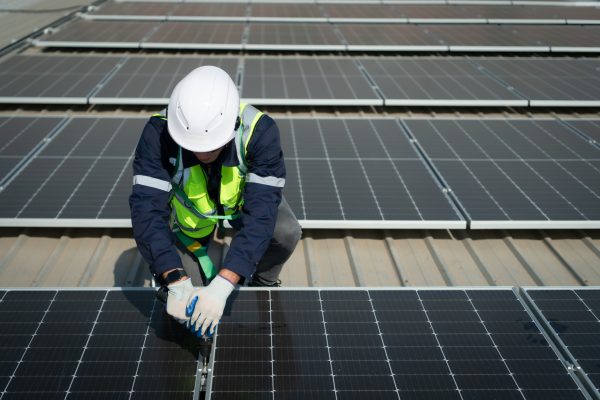 Engineer in charge of solar panel installation The installation of solar energy conversion into electricity for a warehouse is currently being investigated.
